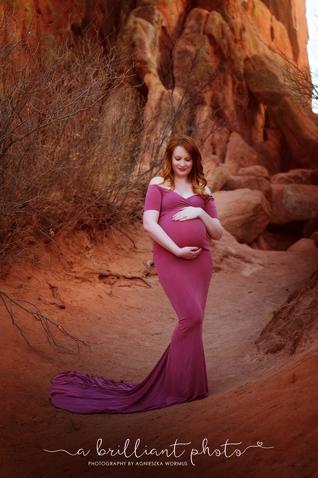 Glamorous Maternity Portrait at Garden of the Gods Park in Colorado Springs by A Brilliant Photo - Photography by Agnieszka Wormus, Fort Collins Photographer. Red rocks, Redheaded mommy to be, magenta purple maternity gown. 